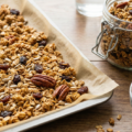 Gros plan sur les pépites dorées et croustillantes du granola maison healthy aux noix de pécan et raisins secs.